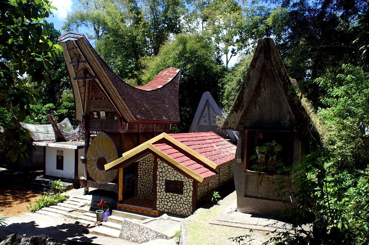 Traditional carved houses shaded by trees at Kete Kesu